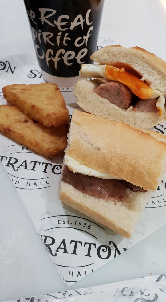 Perfect Breakfast takeaway from Stratton Food Hall Hash browns with a sausage and egg roll next to a takeaway cup of coffee